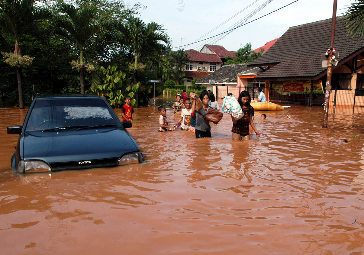 Dua orang wanita penyelamatkan barang-barangnya dari rendaman banjir