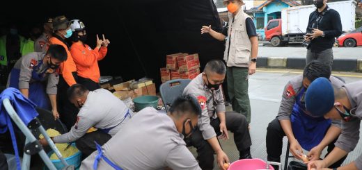 Aparat kepolisian ikut terjun ke dapur umum untuk membantu memperlancar penyaluran kebutuhan pokok para korban banjir.