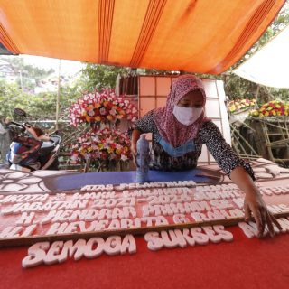 Seorang pedagang bunga di Pasar Kalisari Semarang merapikan karangan bunga pesanan pelangan.