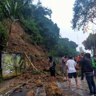 Petugas BPBD Kota Semarang dibantu masyarakat sekitar membersihan longsoran tanah yang menutupi Jalan Gombel lama