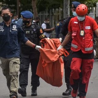 Petugas membawa potongan tubuh yang diduga pelaku bom bunuh diri di Gereja Katedral Makassar