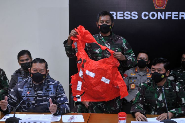 Panglima TNI Marsekal TNI Hadi Tjahjanto (kanan) dan Kepala Staf Angkatan Laut Laksamana TNI Yudo Margono (kiri) menunjukkan baju keselamatan awak kapal KRI Nanggala 402 yang ditemukan saat konferensi pers di Lanud I Gusti Ngurah Rai, Badung, Bali, Minggu (25/4)
