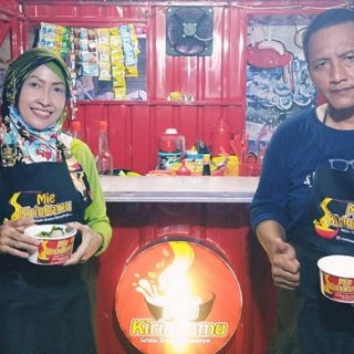 Nancy dan suaminya berpose dengan membawa mie ayam andalan