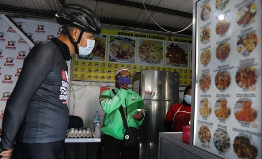 Gubernur Ganjar Pranowo bersepeda pagi dan singgah di pedagang bubur ayam Legenda di Majapahit, Semarang, Senin (26/7). Pemilik bubur ayam Legenda menyediakan sarapan gratis bagi warga terpapar Covid yang sedang menjalani isolasi mandiri dan kesulitan mendapatkan makanan