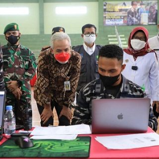 Gubernur Jateng Ganjar Pranowo berbincang dengan Letnan Always Tiris yang sibuk dengan laptopnya pada acara Serbuan Vaksinasi Covid-19 Koarmada II di Kabupaten Tegal, Rabu (25/8)