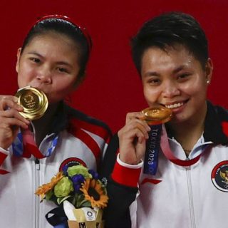 Greysia Polii/Apriyani Rahayu mencium medali emas ganda putri Olimpiade Tokyo 2020. Pada laga final, Greysia/Apriyani mengalahkan pasangan China, Chen Qing Chen/Jia Yi Fan dua set langsung 21-19 dan 21-15.