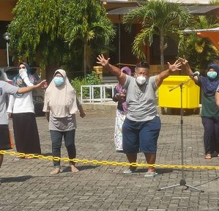 Para penderita Covid-19 yang sedang menjalani isolasi di BPSDMD Jawa Tengah, bergoyang bersama saat mendapat hiburan dari mahasiswa dan penyanyi dangdut Ressa Lawangsewu, Senin (2/8)