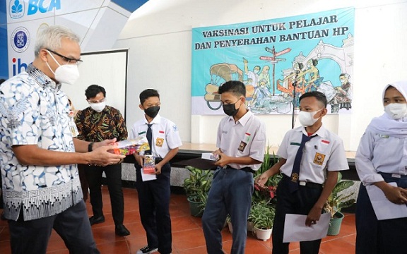 Gubernur Jateng Ganjar Pranowo dan Wali Kota Solo Gibran Rakabuming Raka melihat vaksinasi Covid-19 untuk pelajar di SMAN 3 Surakarta dan memberikan handphone, Rabu (4/8).