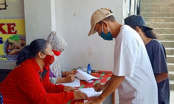 Warga Randusari Semarang mengisi daftar hadir pada program vaksinasi Covid-19 yang digagas Puskesmas Randusari di Tepian Kopi, Taman Kasmaran, Rabu (15/9).