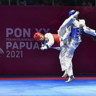 Taekwondoin Jateng Reinaldy Atmanegara (sabuk merah) melepaskan tendangan ke arah Dhiva Rahmani Sonjaya dari Jabar di final kelas -54 kg PON.