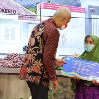Gubernur Jateng Ganjar Pranowo menyerahkan secara simbolis santunan kematian dari BPJS Ketenagakerjaan kepada Suprinah lewat program Mesra dengan Ganjar