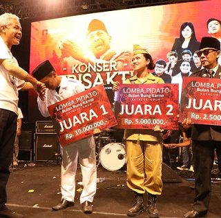 Gubernur Jawa Tengah, Ganjar Pranowo, menyerahkan hadiah kepada para juara Lomba Pidato Bung Karno di sela Konser Trisakti di Benteng Vastenburg Solo, Sabtu (25/6) malam