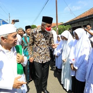 Gubernur Jateng Ganjar Pranowo disambut pengasuh Ponpes An-Nawawi Purworejo, KH Achmad Chalwani Nawawi, dan para santri saat menghadiri pengajian Sewelasan dan Bai'at Thariqot, Minggu (17/7)