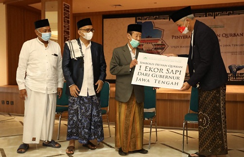 Gubernur Jateng Ganjar Pranowo menyerahkan hewan kurban secara simbolis usai salat Id di Lapangan Simpang Lima,, Semarang, Minggu (10/7). Hewan kurban berupa sapi diterima Ketua Umum YPKPI Masjid Raya Baiturrahman, Ahmad Daroji