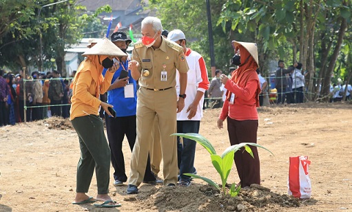 BERBINCANG. Gubernur Jateng Ganjar Pranowo berbincang dengan para petani di sela mendampingi kunjungan kerja Presiden Jokowi di Sukoharjo, Kamis (11/8). Ganjar dan Jokowi juga melakukan penanaman kelapa genjah