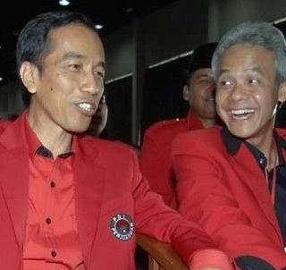 Ganjar Pranowo duduk berdampingan dengan Jokowi pada sebuah acara PDIP