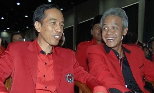 Ganjar Pranowo duduk berdampingan dengan Jokowi pada sebuah acara PDIP