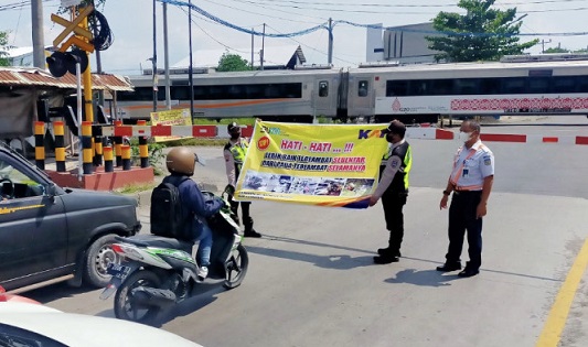 KAI melakukan sosialisasi kepada para pengemudi yang hendak melintas di rel kereta api.