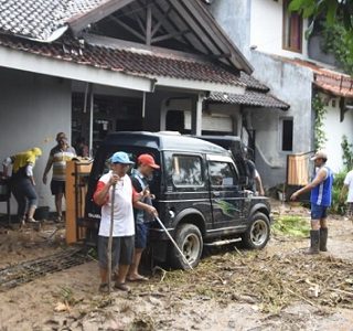 Warga membersihkan lumpur akibat banjir bandang