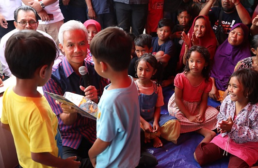 Gubernur Jawa Tengah Ganjar Pranowo menghibur anak-anak dan memberi hadiah, saat mengunjungi tempat pengungsian korban banjir di Kecamatan Pekalongan Barat, Kota Pekalongan, Selasa (3/1/2023)