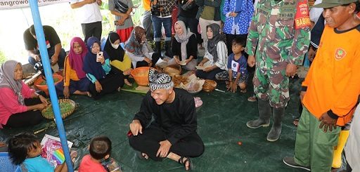 Gubernur Jawa Tengah, Ganjar Pranowo, mengunjungi dan bercengkerama dengan anak-anak dan warga Dukuh Ngelo, Desa Karangrowo, Kecamatan Undaan, Kabupaten Kudus, di balai desa tempat pengungsian akibat banjir, Kamis (12/1/2023)