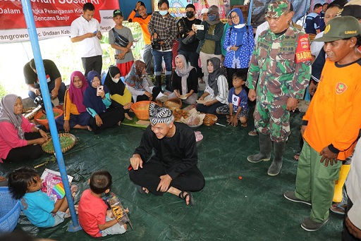 Gubernur Jawa Tengah, Ganjar Pranowo, mengunjungi dan bercengkerama dengan anak-anak dan warga Dukuh Ngelo, Desa Karangrowo, Kecamatan Undaan, Kabupaten Kudus, di balai desa tempat pengungsian akibat banjir, Kamis (12/1/2023)