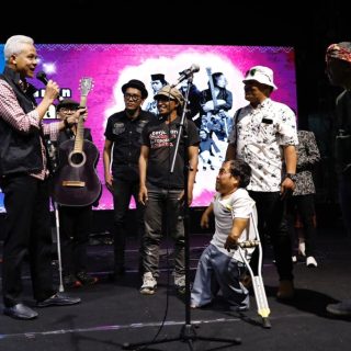 Gubernur Jawa Tengah, Ganjar Pranowo, menenteng gitar kayu tua yang diterimanya dari seorang musisi jalanan di Kota Semarang saat menonton Pentas Apresiasi Musisi Jalanan di Taman Budaya Raden Saleh (TBRS) Semarang, Minggu (3/9/2023) malam