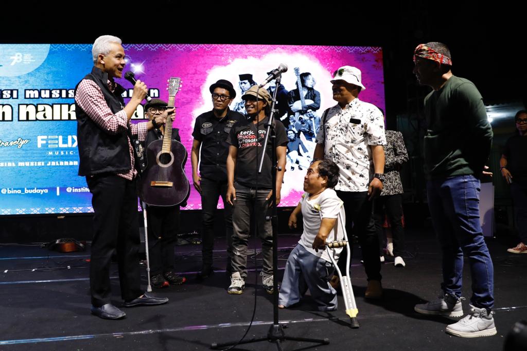 Gubernur Jawa Tengah, Ganjar Pranowo, menenteng gitar kayu tua yang diterimanya dari seorang musisi jalanan di Kota Semarang saat menonton Pentas Apresiasi Musisi Jalanan di Taman Budaya Raden Saleh (TBRS) Semarang, Minggu (3/9/2023) malam