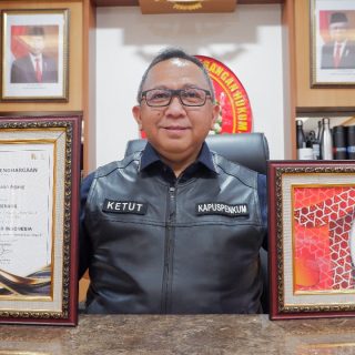 Ketut Sumedana memegang penghargaan