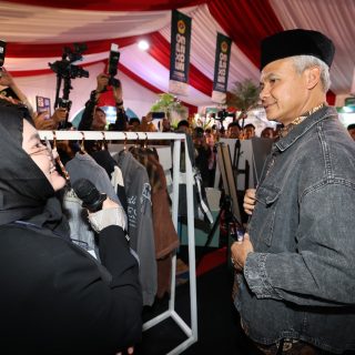 Bakal calon presiden (Bacapres) Ganjar Pranowo, mencoba jaket hasil karya perancang Callista Aldenia, saat mengunjungi Lembaga Dakwah Islam Indonesia (LDII) Expo 2023 di komplek Gedung Minhaajurrosyidiin di Jakarta Timur Rabu (8/11/2023)