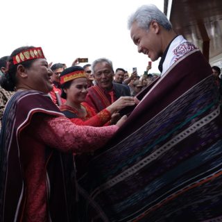 Warga menyematkan kain ulos saat bakal calon presiden (Bacapres) 2024 Ganjar Pranowo, bersilaturahmi dengan tokoh adat Batak di Kabupaten Toba, Tapanuli Utara, Minggu (12/11/2023)