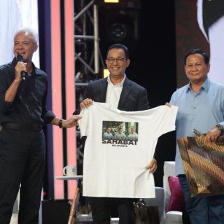 Para Capres 2024, memperlihatkan hadiah dari Ganjar berupa kaos dan topi siswa SD dalam acara 13 Tahun Mata Najwa di Taman Ismail Marzuki, Jakarta, Minggu (19/11/2023) malam