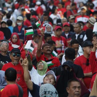 Bendera Palestina berkibar di tengah massa yang berjubel mengikuti Jalan Sehat Perjuangan yang dihadiri Capres 2024 Ganjar Pranowo di Makassar, Minggu (26/11/2023)