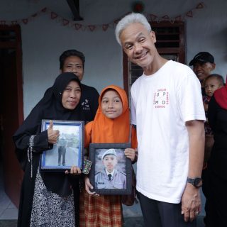 Diarni dan keluarga bersama Capres Ganjar Pranowo menunjukkan foto Fahri Huzaini, lulusan SMKN Jawa Tengah yang kini menjadi anggota TNI